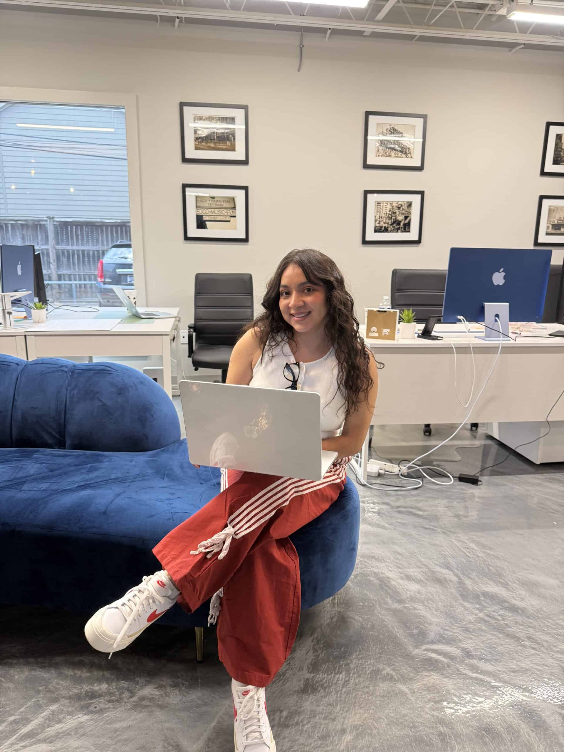 Team member working on a laptop in a casual lounge area at the Big River Digital office